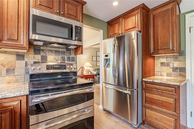 15 Chesapeake Lndg, Henrietta, NY 14586 - kitchen featuring stainless steel appliances, light wood-type flooring, light stone countertops, brown cabinets, and recessed lighting