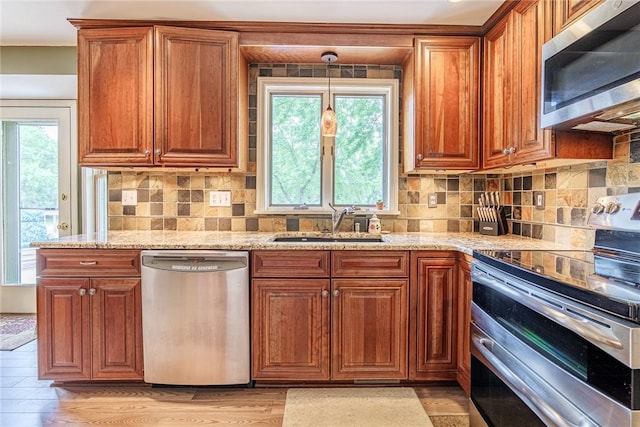 15 Chesapeake Lndg, Henrietta, NY 14586 - kitchen with appliances with stainless steel finishes, brown cabinetry, light stone counters, and tasteful backsplash