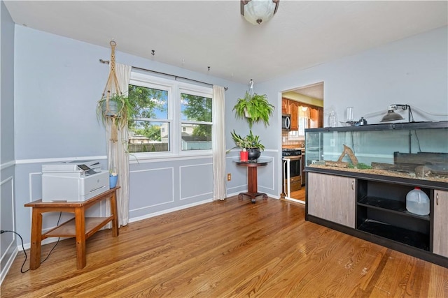 99 Dorian Ln, Greece, NY 14626 - dining room featuring light wood-type flooring, a decorative wall, and a wainscoted wall