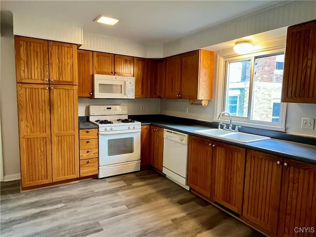 152 W Cayuga St, Oswego, NY 13126 - kitchen featuring white appliances, dark countertops, light wood-type flooring, and brown cabinets