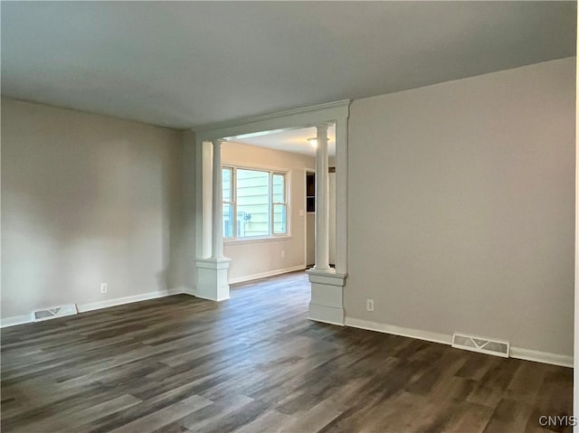 152 W Cayuga St, Oswego, NY 13126 - spare room featuring decorative columns and dark wood-type flooring