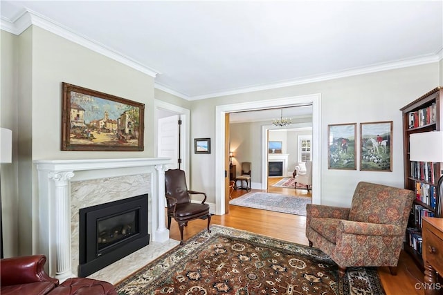 49 Academy St, Skaneateles, NY 13152 - living area with a high end fireplace, wood finished floors, a chandelier, and ornamental molding