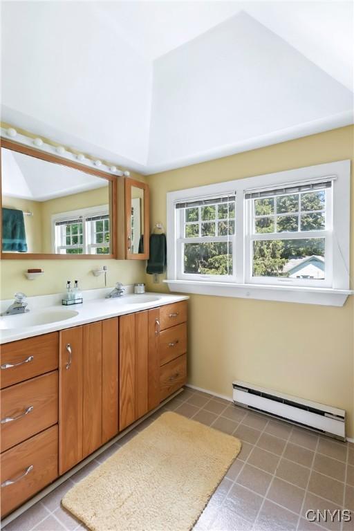 49 Academy St, Skaneateles, NY 13152 - full bath featuring a baseboard heating unit, double vanity, lofted ceiling, and tile patterned floors