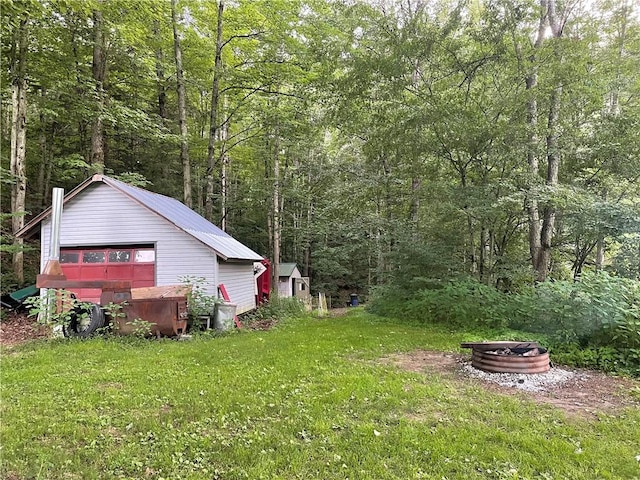 1571 State Highway 7, Afton, NY 13730 - view of green lawn featuring a view of trees, a storage shed, a garage, and an outdoor fire pit