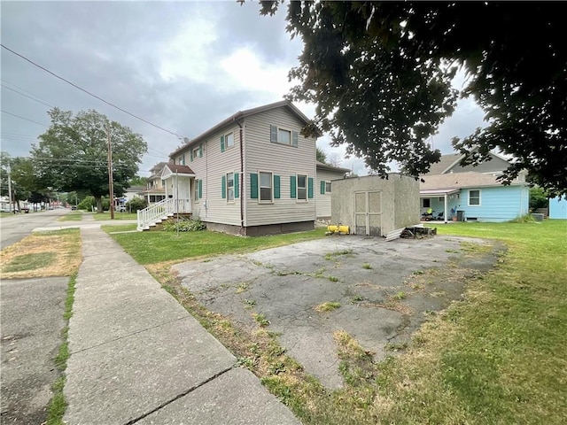 27 Chestnut Ave, North Dansville, NY 14437 - view of side of property featuring a storage unit and a yard