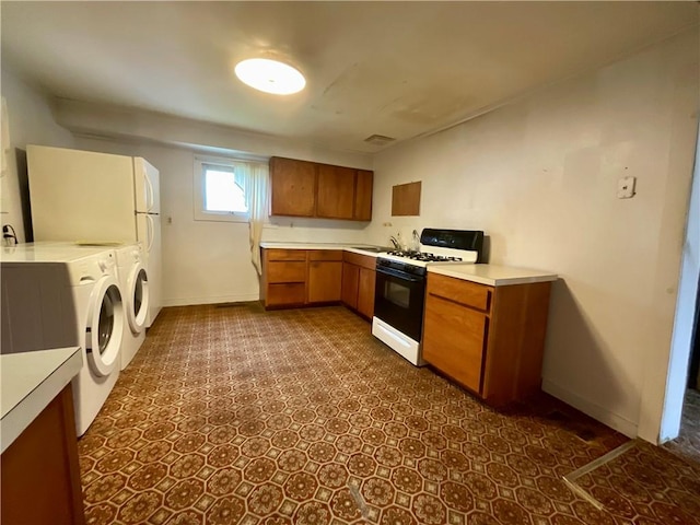 27 Chestnut Ave, North Dansville, NY 14437 - kitchen with gas range, brown cabinetry, light countertops, and independent washer and dryer