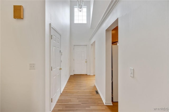 25 Caspian Ct, Amherst, NY 14228 - hall with light wood-type flooring, a high ceiling, and a chandelier