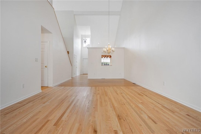 25 Caspian Ct, Amherst, NY 14228 - unfurnished living room featuring a chandelier, light wood-type flooring, and a high ceiling