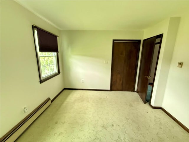 5 Riverside Ave, Oneonta, NY 13820 - unfurnished bedroom featuring a baseboard heating unit and light carpet