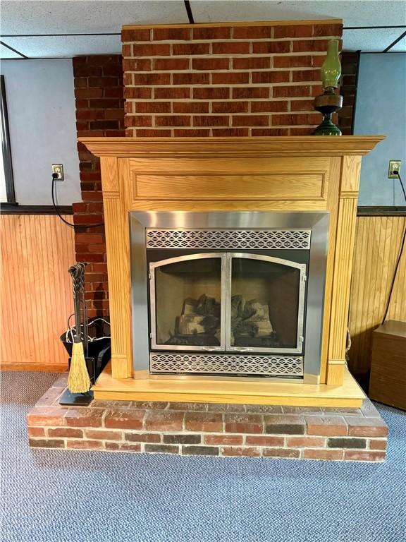 5 Riverside Ave, Oneonta, NY 13820 - detailed view of a large fireplace, wood walls, carpet floors, a drop ceiling, and wainscoting