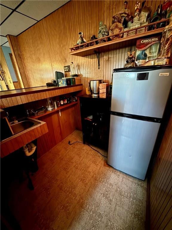 5 Riverside Ave, Oneonta, NY 13820 - kitchen featuring freestanding refrigerator, wooden walls, and wood finished floors