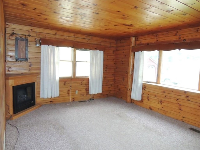 751 County Rd 17, Bainbridge, NY 13733 - unfurnished living room featuring carpet floors, plenty of natural light, wood walls, a fireplace, and wood ceiling