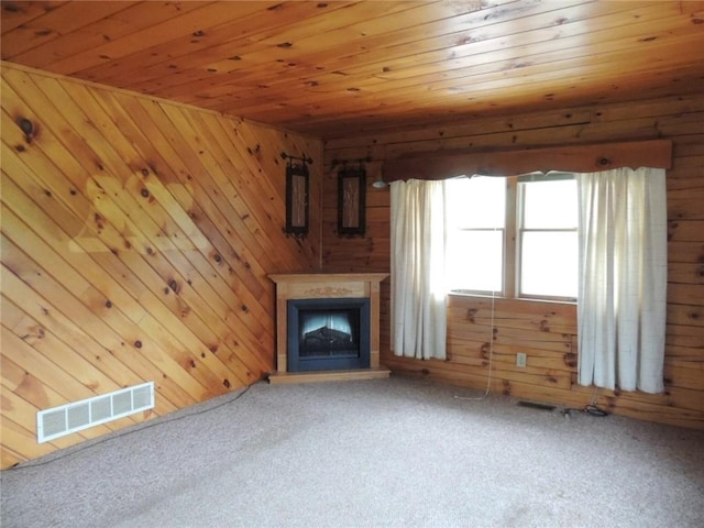751 County Rd 17, Bainbridge, NY 13733 - unfurnished living room with carpet flooring, wood walls, wooden ceiling, and a fireplace with raised hearth