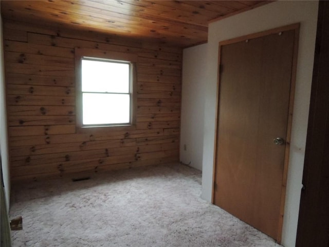 751 County Rd 17, Bainbridge, NY 13733 - unfurnished bedroom with wooden ceiling, wooden walls, carpet flooring, and a closet