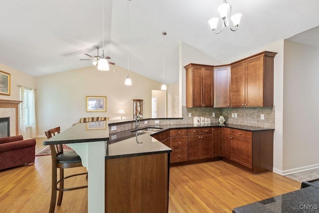 8449 Newbury Pl, Clay, NY 13041 - kitchen with light wood finished floors, open floor plan, a kitchen bar, backsplash, and a ceiling fan