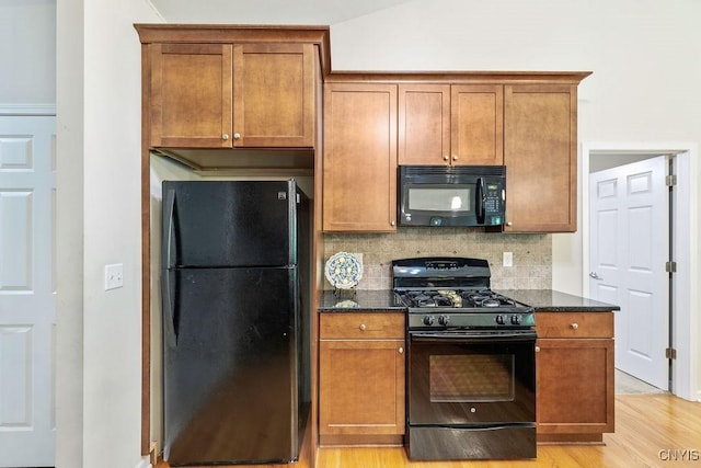 8449 Newbury Pl, Clay, NY 13041 - kitchen with black appliances, dark stone countertops, tasteful backsplash, and light wood finished floors