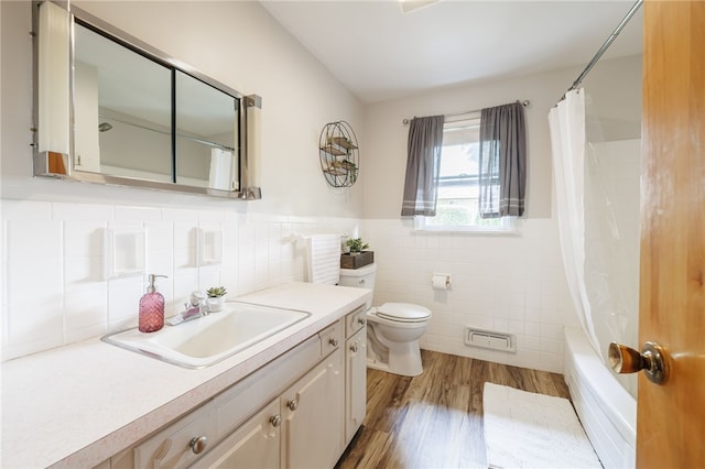 118 Fern Castle Dr, Irondequoit, NY 14622 - bathroom featuring tile walls, wood finished floors, vanity, shower / tub combo, and a wainscoted wall