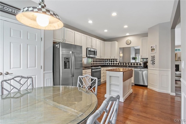 115 Shire Way, Camillus, NY 13031 - kitchen featuring appliances with stainless steel finishes, tasteful backsplash, a kitchen island, white cabinets, and wood finished floors