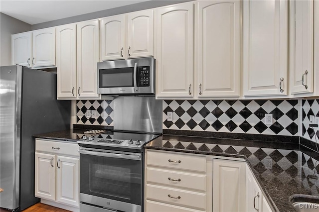 115 Shire Way, Camillus, NY 13031 - kitchen with appliances with stainless steel finishes, white cabinetry, decorative backsplash, and dark stone counters