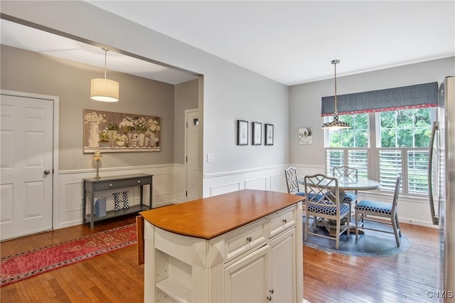 115 Shire Way, Camillus, NY 13031 - kitchen with light wood-style flooring, a wainscoted wall, stainless steel refrigerator, white cabinets, and pendant lighting