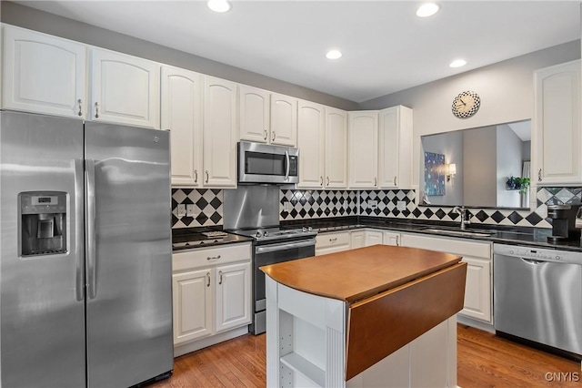 115 Shire Way, Camillus, NY 13031 - kitchen featuring stainless steel appliances, dark countertops, white cabinets, tasteful backsplash, and recessed lighting