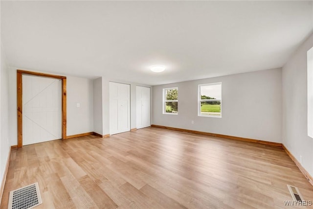 10655 Millers Rd, Yates, NY 14098 - unfurnished bedroom featuring light wood-style floors and multiple closets