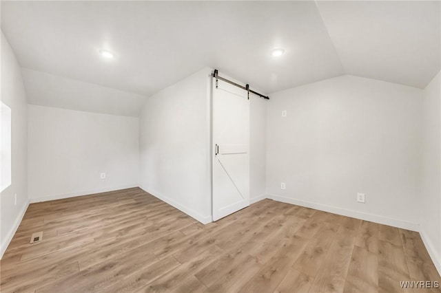 10655 Millers Rd, Yates, NY 14098 - bonus room with a barn door, vaulted ceiling, light wood finished floors, and recessed lighting