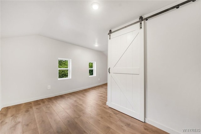 10655 Millers Rd, Yates, NY 14098 - empty room with a barn door, light wood-type flooring, recessed lighting, and lofted ceiling