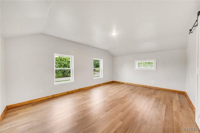 10655 Millers Rd, Yates, NY 14098 - empty room with vaulted ceiling, light wood-type flooring, and a barn door