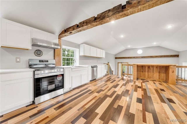 10655 Millers Rd, Yates, NY 14098 - kitchen featuring stainless steel appliances, wall chimney range hood, lofted ceiling, light countertops, and light wood-style flooring