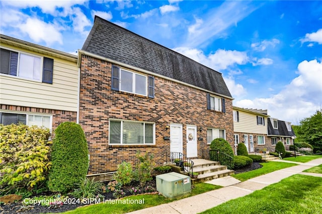 35 Stoneledge, Amherst, NY 14221 - view of property featuring brick siding, a front yard, and roof with shingles