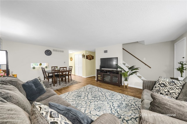 35 Stoneledge, Amherst, NY 14221 - living room featuring wood finished floors, stairs, and a textured ceiling