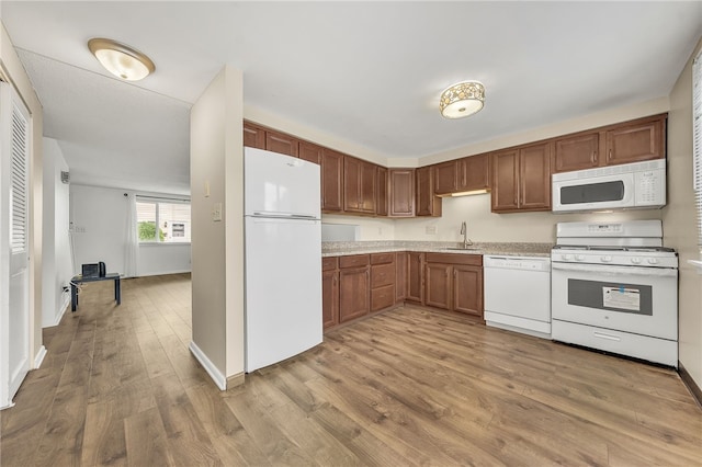 35 Stoneledge, Amherst, NY 14221 - kitchen featuring white appliances, light countertops, light wood-type flooring, and brown cabinetry