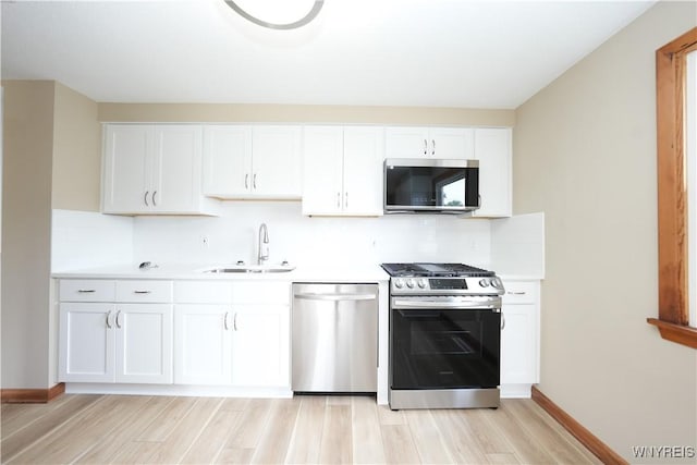 22 Vanderbilt Ave, Cheektowaga, NY 14043 - kitchen featuring appliances with stainless steel finishes, decorative backsplash, light wood-style flooring, light countertops, and white cabinets