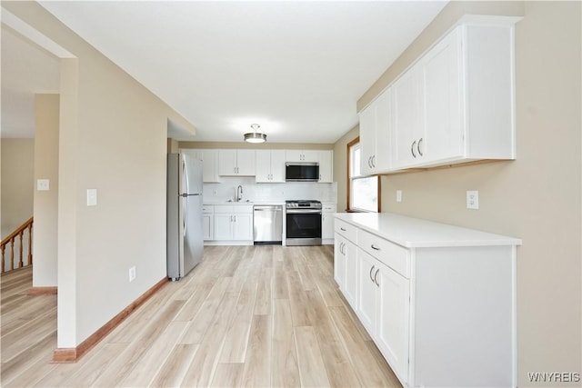 22 Vanderbilt Ave, Cheektowaga, NY 14043 - kitchen featuring appliances with stainless steel finishes, light wood-style floors, light countertops, and white cabinets