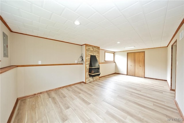 22 Vanderbilt Ave, Cheektowaga, NY 14043 - empty room with crown molding, a wood stove, electric panel, and light wood-style flooring