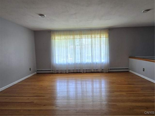 4777 Glencrest Ave, Clay, NY 13088 - spare room featuring wood finished floors and baseboard heating
