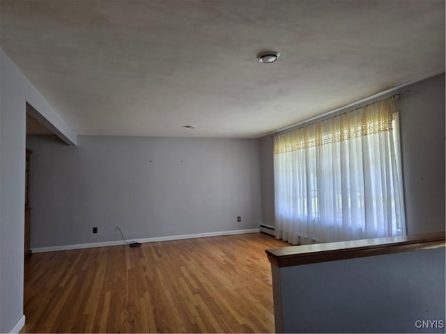 4777 Glencrest Ave, Clay, NY 13088 - empty room featuring wood finished floors and a baseboard heating unit