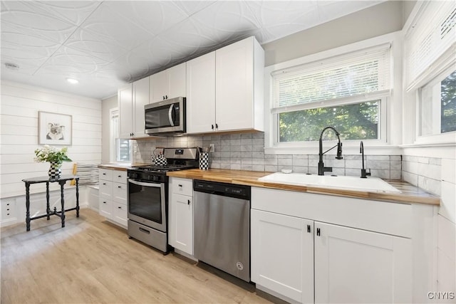 200 Audubon Rd, Manlius, NY 13066 - kitchen with appliances with stainless steel finishes, butcher block counters, white cabinets, decorative backsplash, and recessed lighting