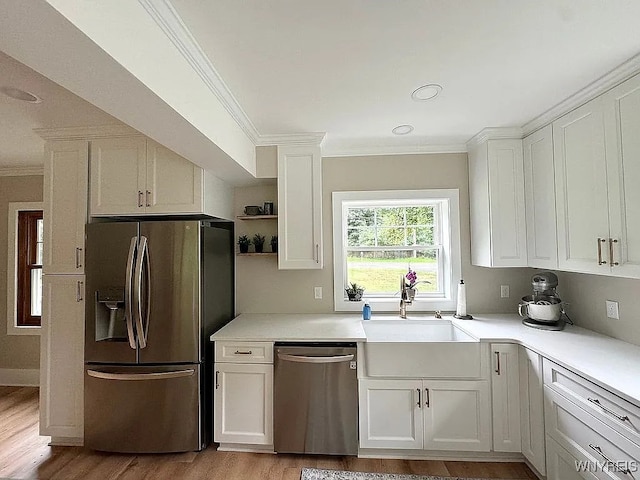 10448 Clarence Center Rd, Clarence, NY 14031 - kitchen with appliances with stainless steel finishes, ornamental molding, white cabinetry, light countertops, and light wood finished floors