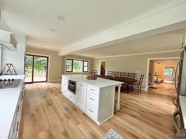 10448 Clarence Center Rd, Clarence, NY 14031 - kitchen featuring cooktop, light wood finished floors, white cabinets, ornamental molding, and light countertops