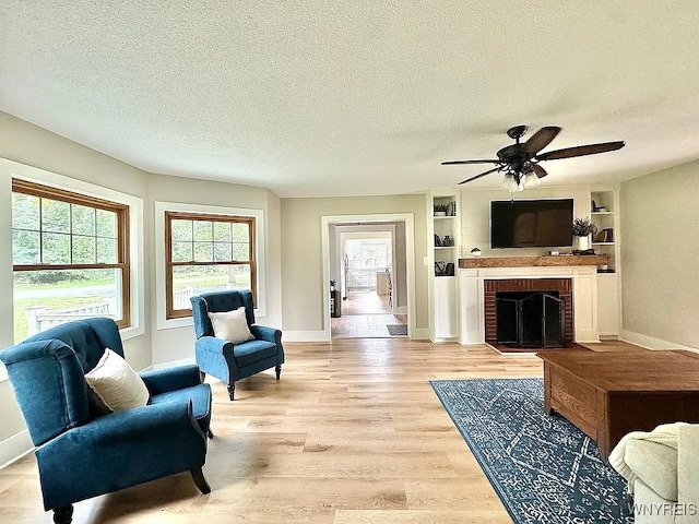 10448 Clarence Center Rd, Clarence, NY 14031 - living room with a textured ceiling, ceiling fan, light wood finished floors, and a brick fireplace