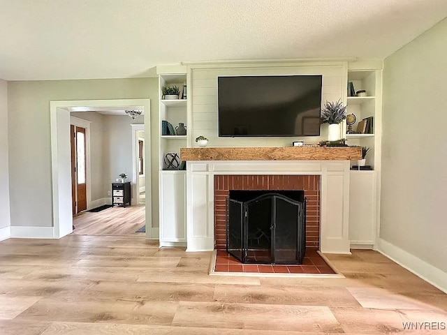 10448 Clarence Center Rd, Clarence, NY 14031 - living area with light wood-style flooring, built in shelves, and a fireplace