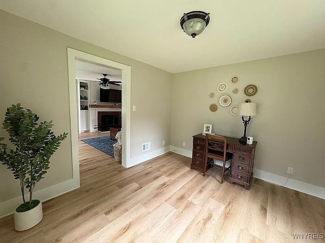 10448 Clarence Center Rd, Clarence, NY 14031 - office area with light wood finished floors, a brick fireplace, and ceiling fan