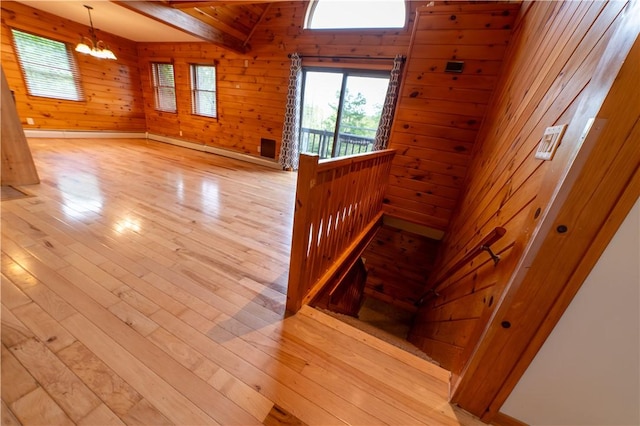 817 Flax Island Rd, Otego, NY 13825 - stairway featuring a chandelier, wooden walls, wood finished floors, and beam ceiling