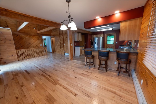 817 Flax Island Rd, Otego, NY 13825 - kitchen featuring stainless steel refrigerator with ice dispenser, wood walls, a baseboard heating unit, light wood finished floors, and dark countertops