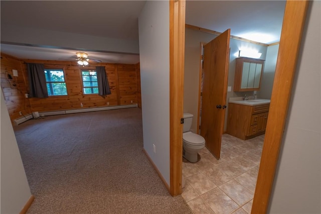817 Flax Island Rd, Otego, NY 13825 - corridor with a baseboard heating unit, wood walls, light colored carpet, and light tile patterned floors