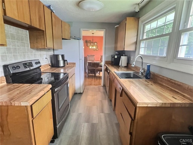 210 Wynnfield Dr, Camillus, NY 13219 - kitchen featuring stainless steel electric range oven, butcher block counters, decorative backsplash, light wood finished floors, and brown cabinets
