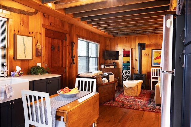 5681 Leidenfrost Adams Rd, Hector, NY 14841 - dining room with wood walls, wood finished floors, a wood stove, and beamed ceiling