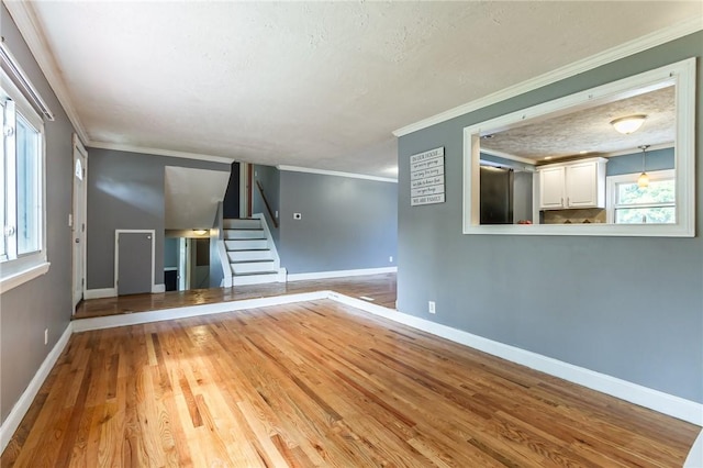 209 Thompson Rd, Henrietta, NY 14623 - unfurnished living room featuring wood finished floors, stairs, ornamental molding, and a textured ceiling